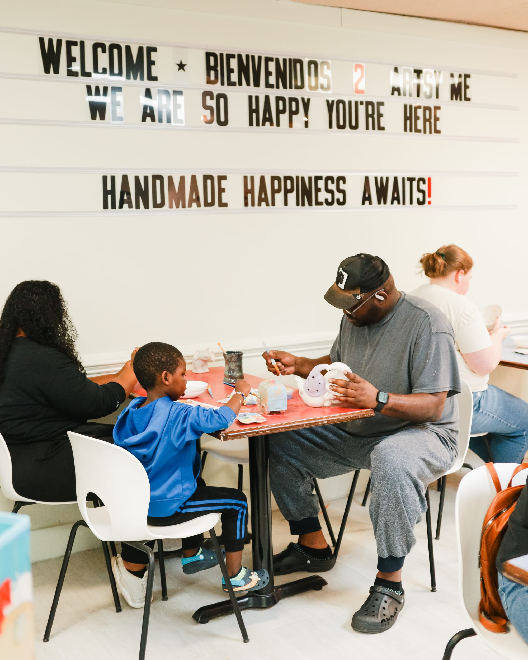 A family painting pottery together at Artsy Me