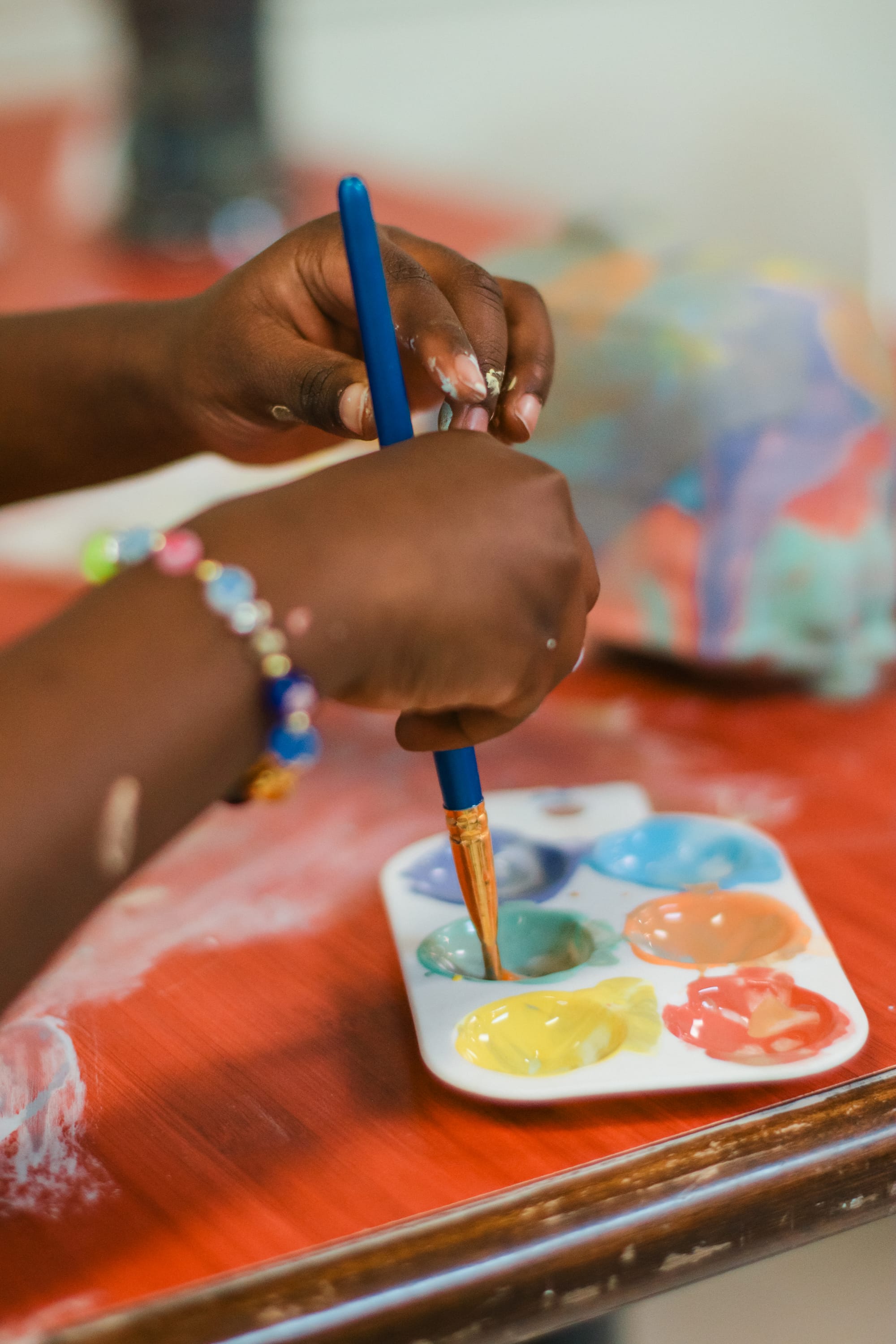 A little kid's hands carefully painting a piece