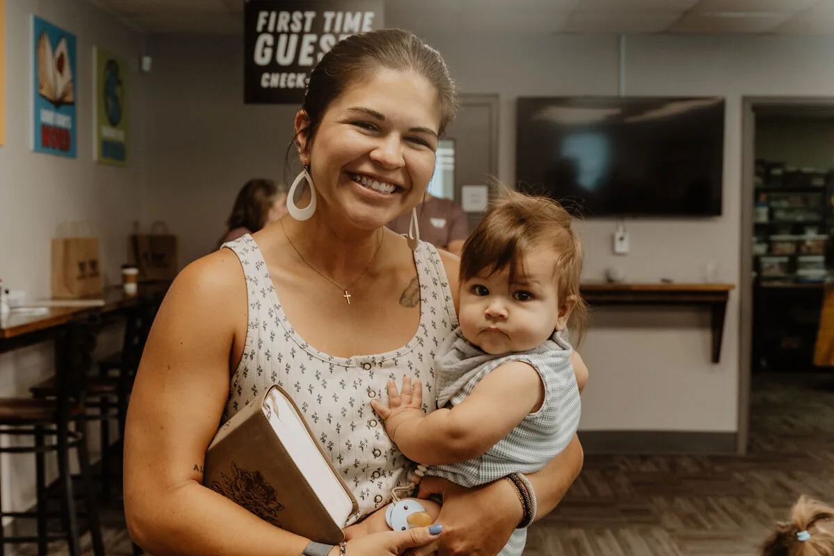 A mother holding her baby at the first-time guest desk.