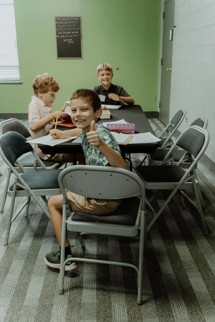 Children at the tables in a kids classroom.