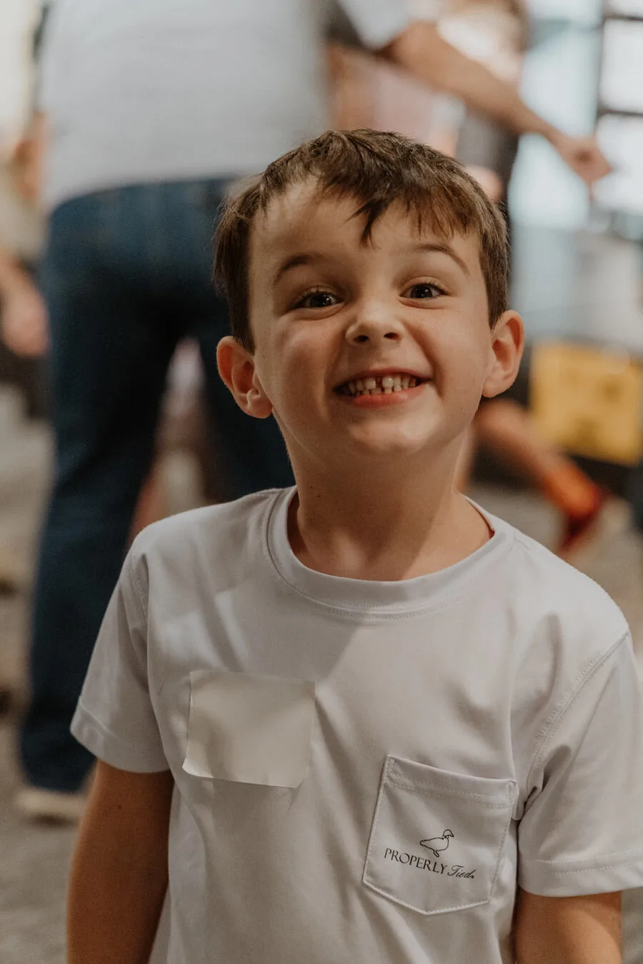 A boy in a name tag, smiling.