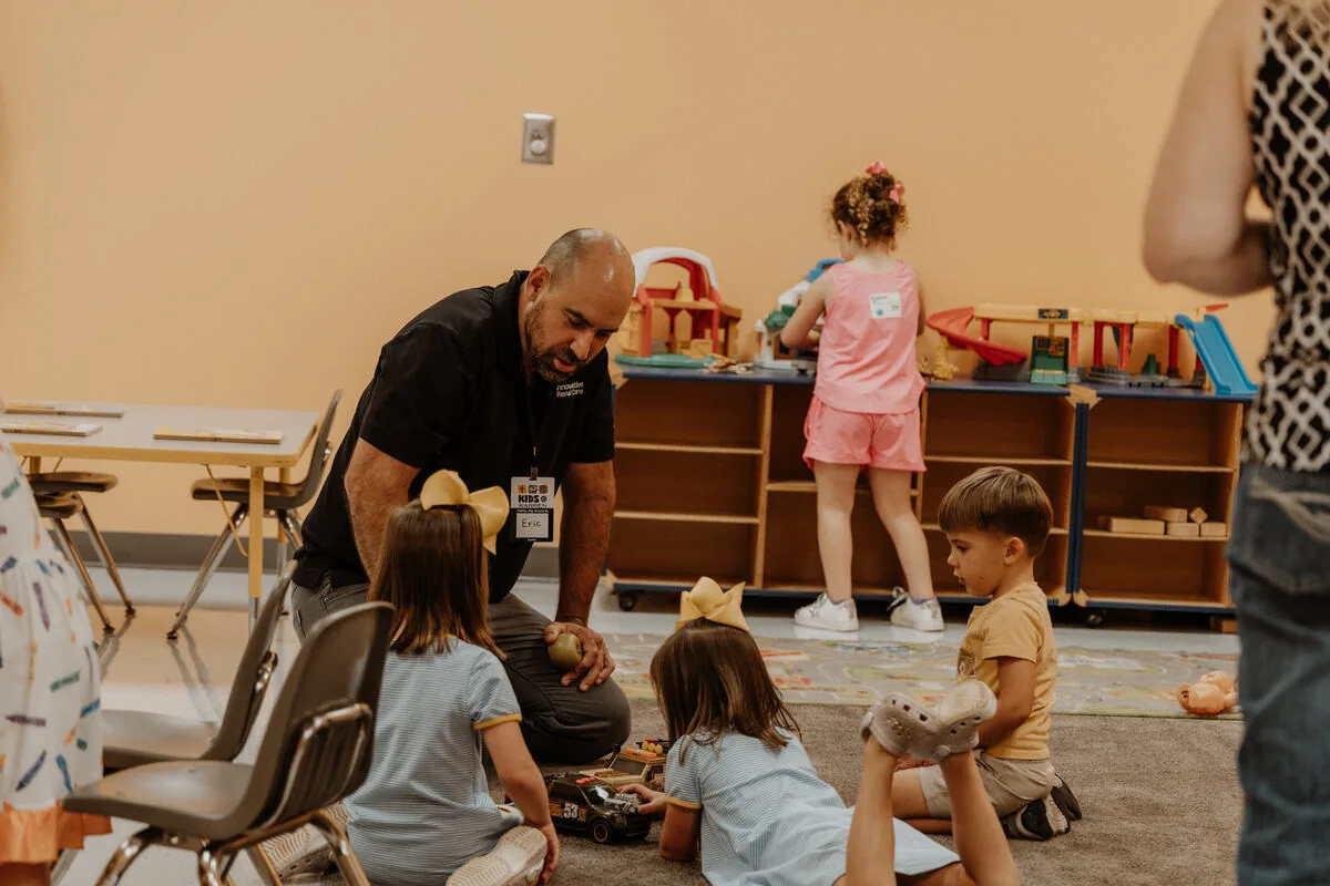 A leader on the floor with the youngest children.