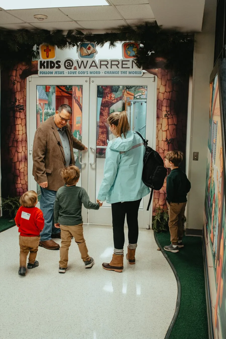 A family walking in through the Kids@Warren doors.