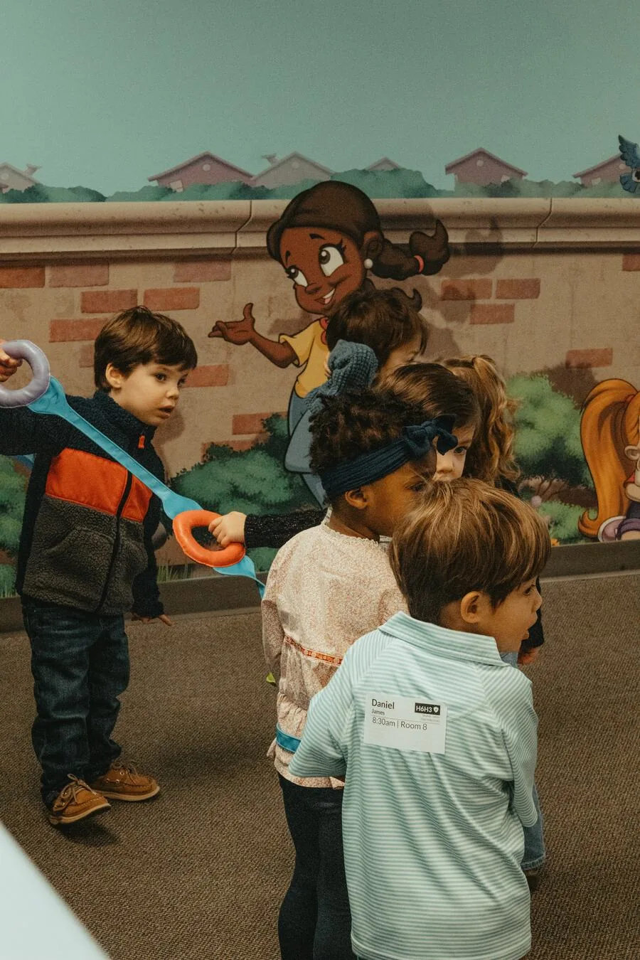 Children playing together by the mural wall.