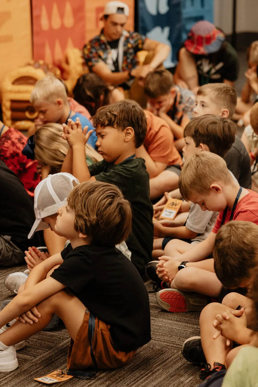 Children sitting on the floor, listening.