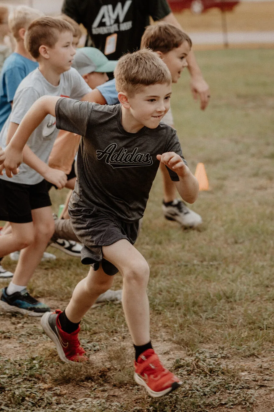 Children running outside on the grass.