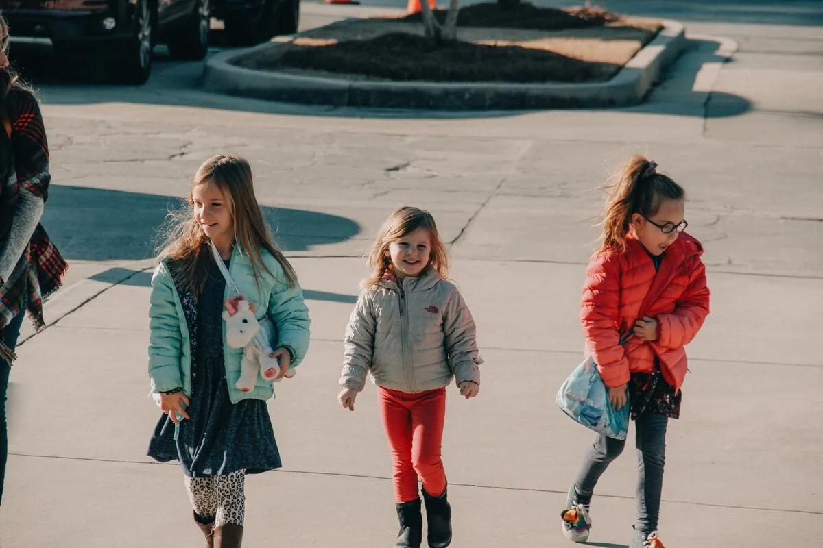 Three children walking up together.