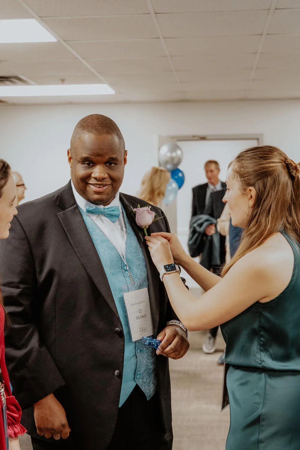 A volunteer pinning on a boutonniere.