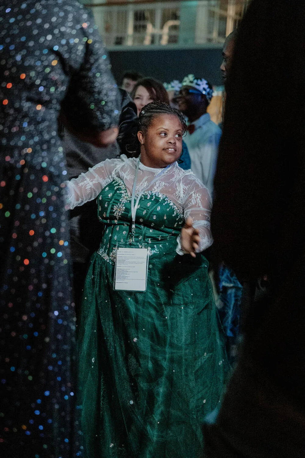 A guest in a green gown under the lights.