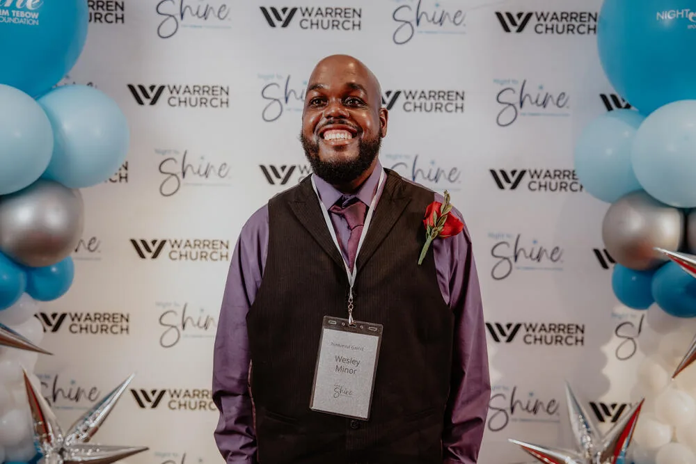A guest photographed at the Night to Shine backdrop.