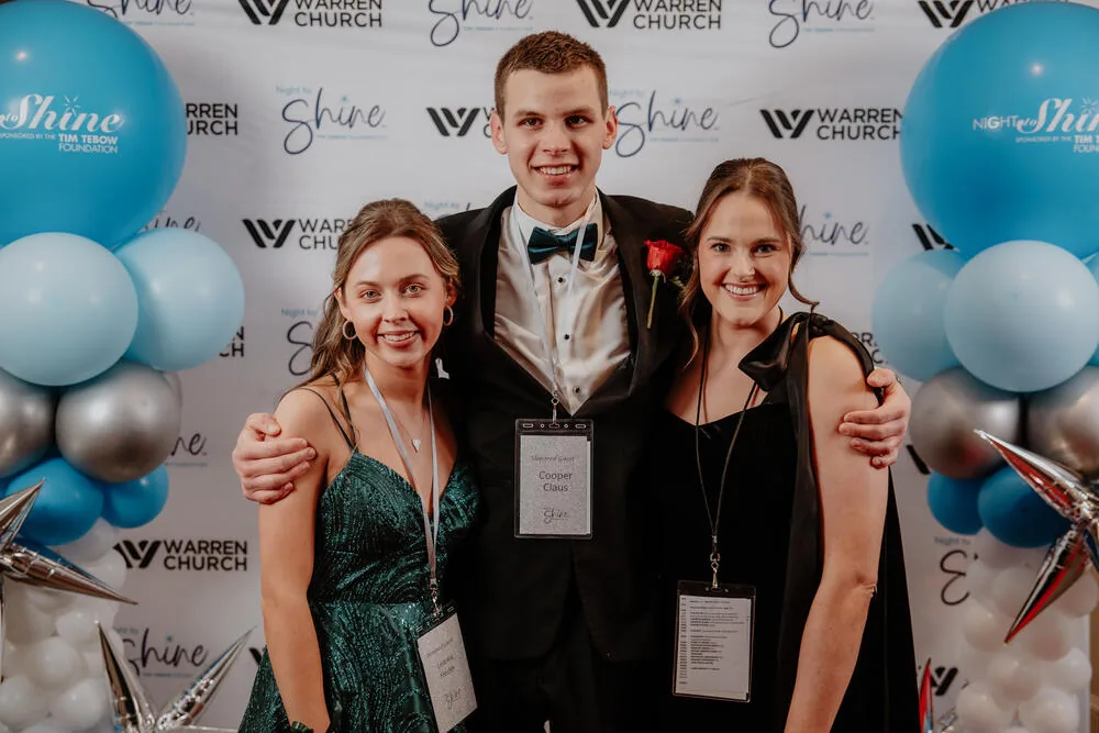 A guest with volunteers at the backdrop.