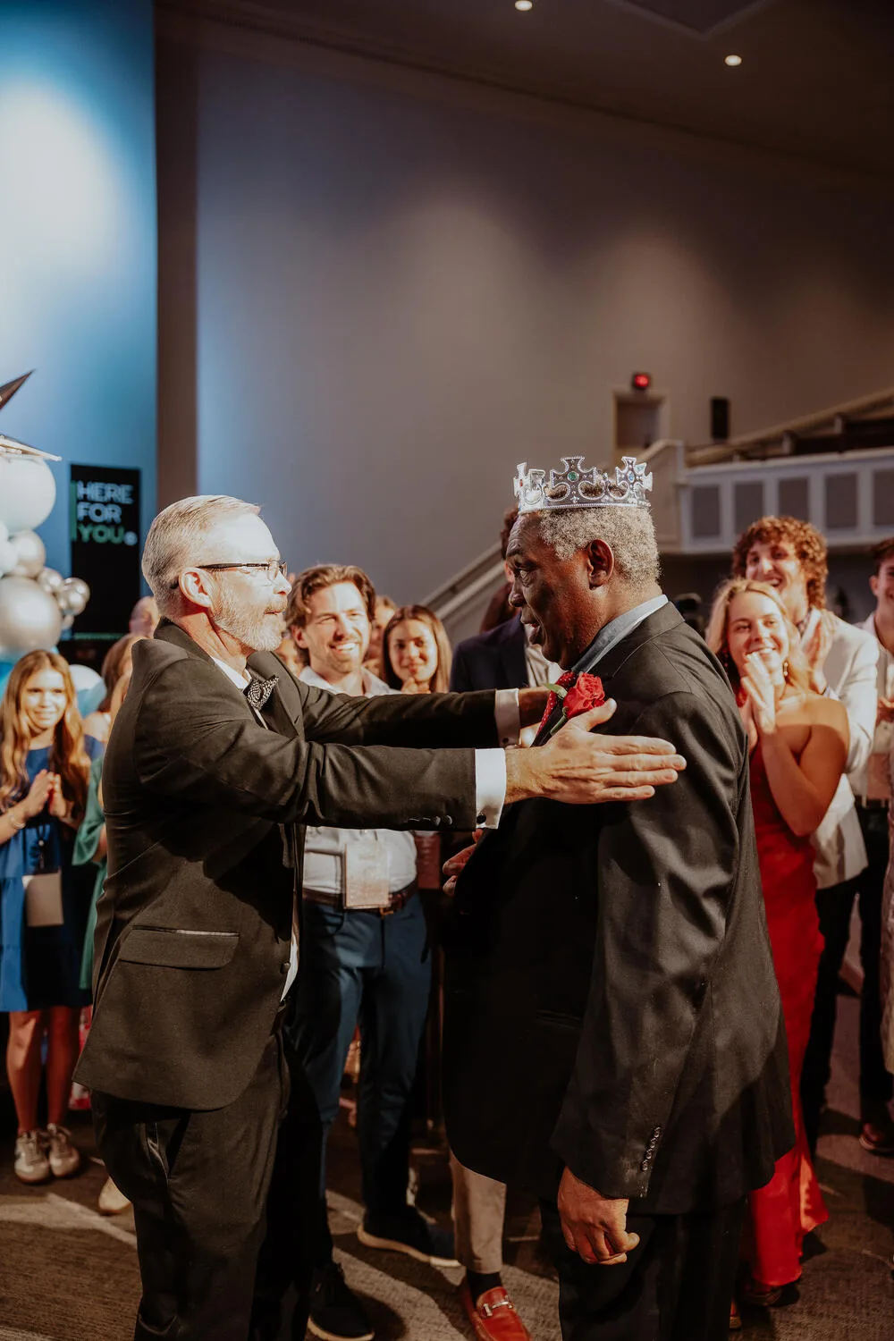 A volunteer welcoming a crowned guest.
