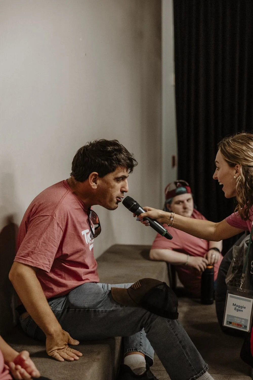 A leader with a microphone beside a participant.