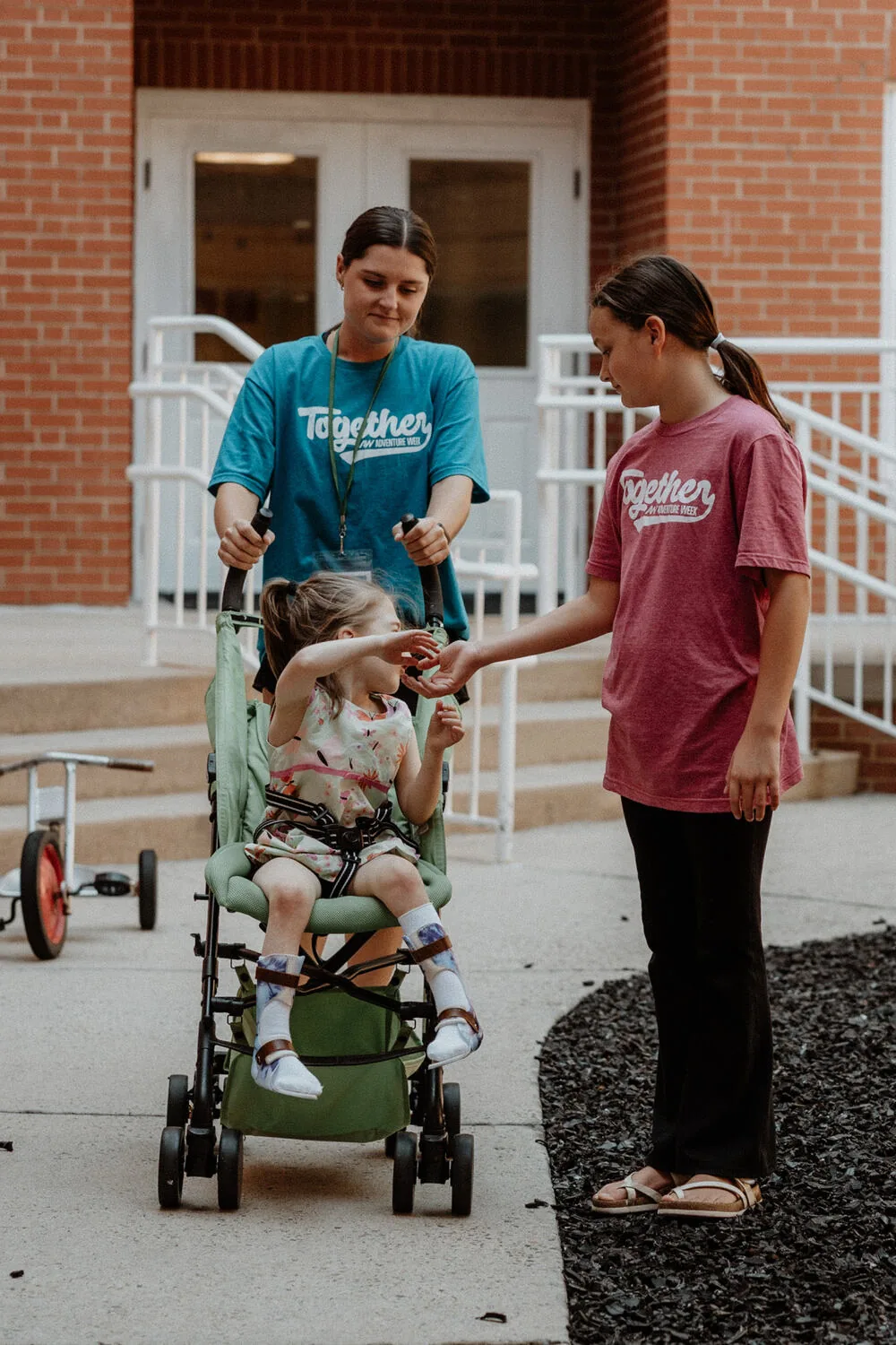 A volunteer walking outside with a family.