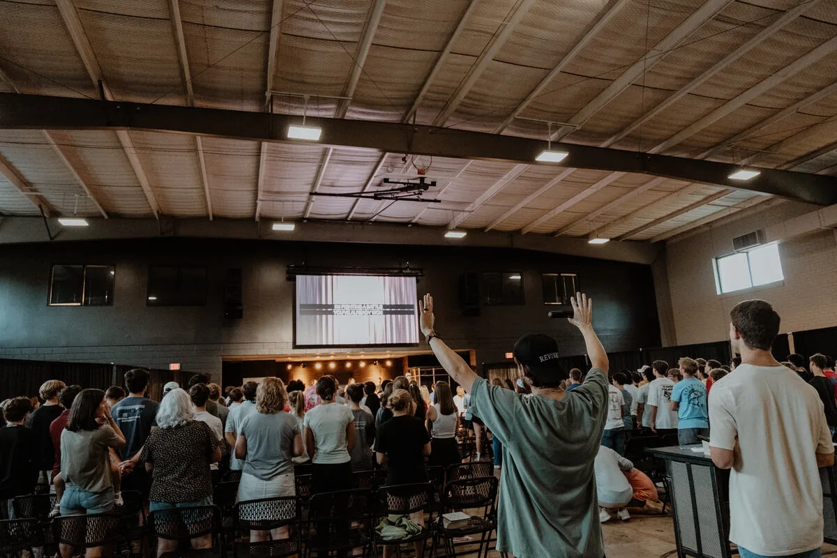 Hands raised across the room during worship.