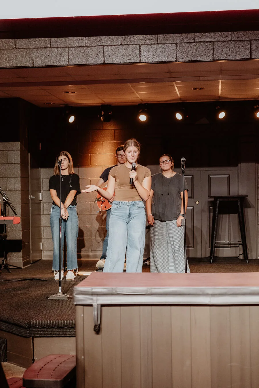 Students on stage with a microphone.