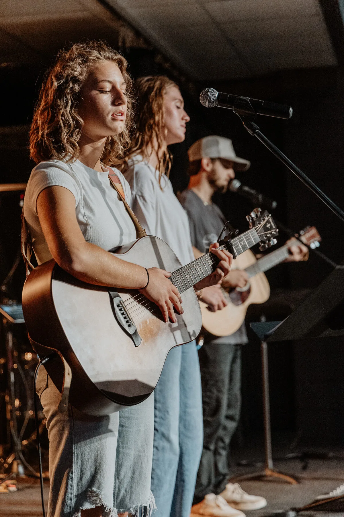 Two students singing with a guitarist.