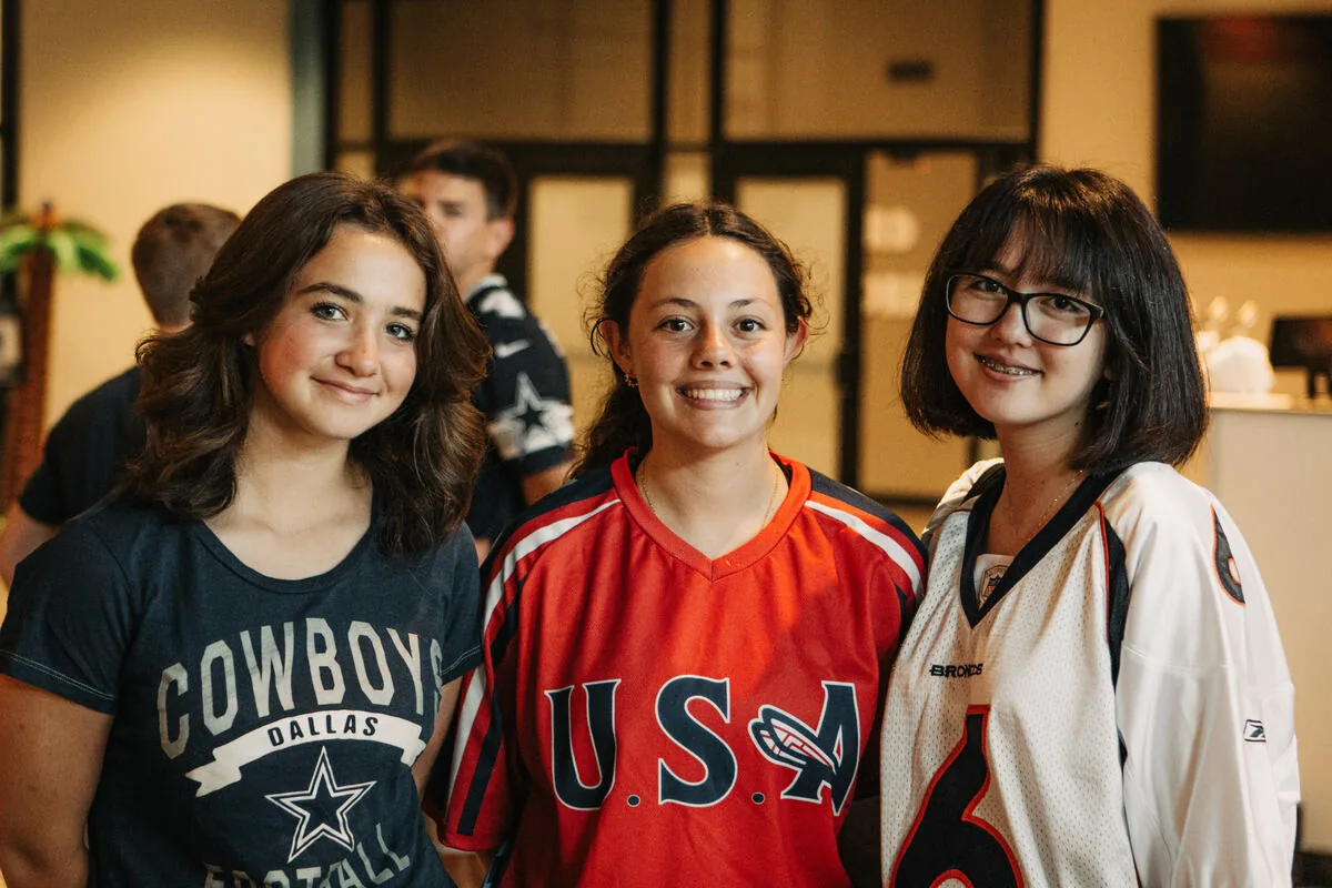 Three students in jerseys, smiling.