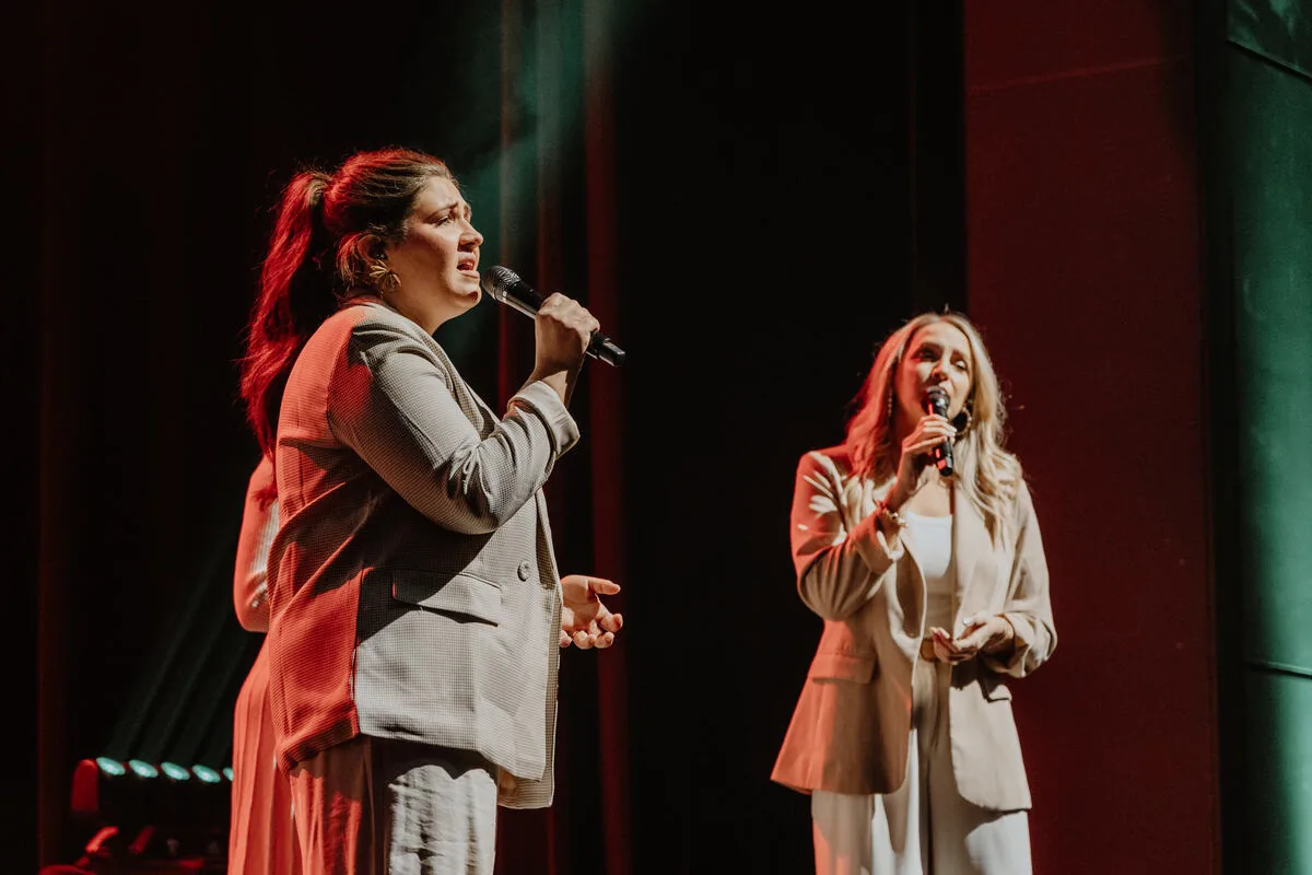 Two vocalists singing together.