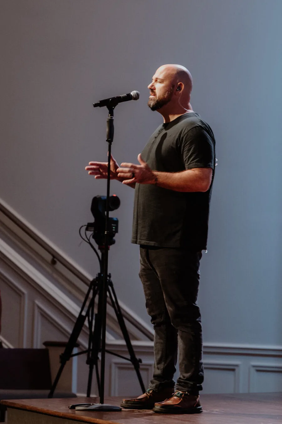 A worship leader singing at the microphone.