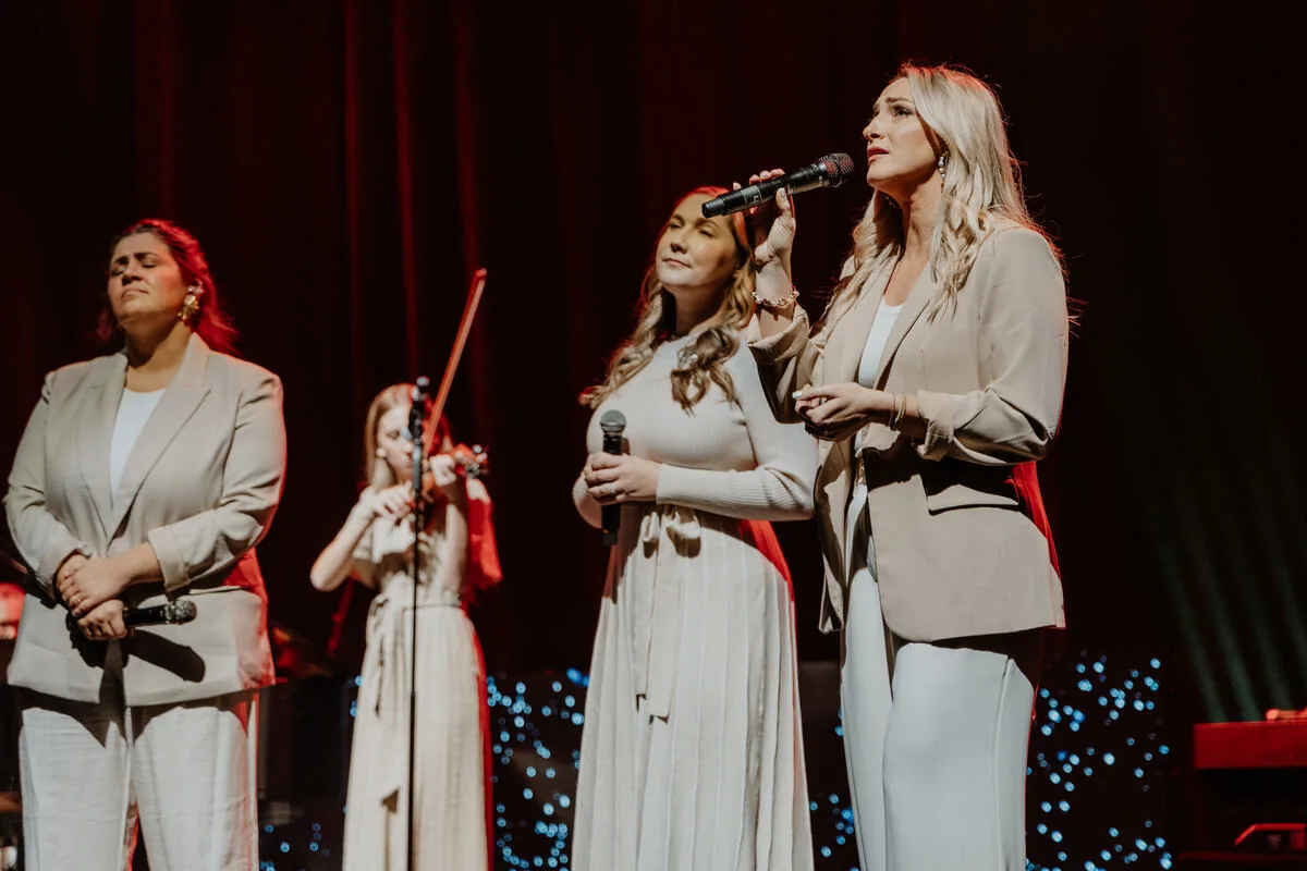 Singers and a violinist on stage together.