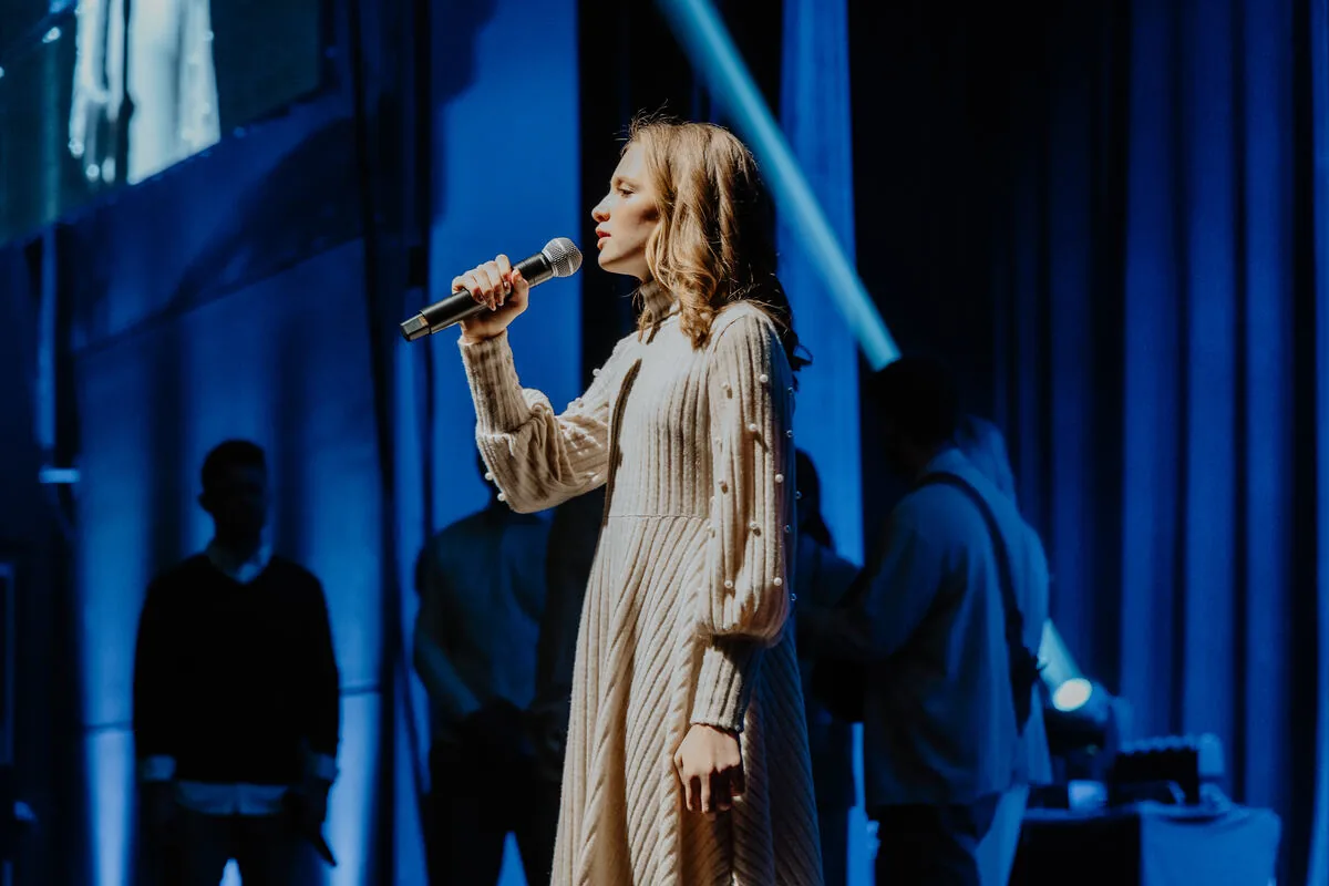 A vocalist mid-song, lit in blue.