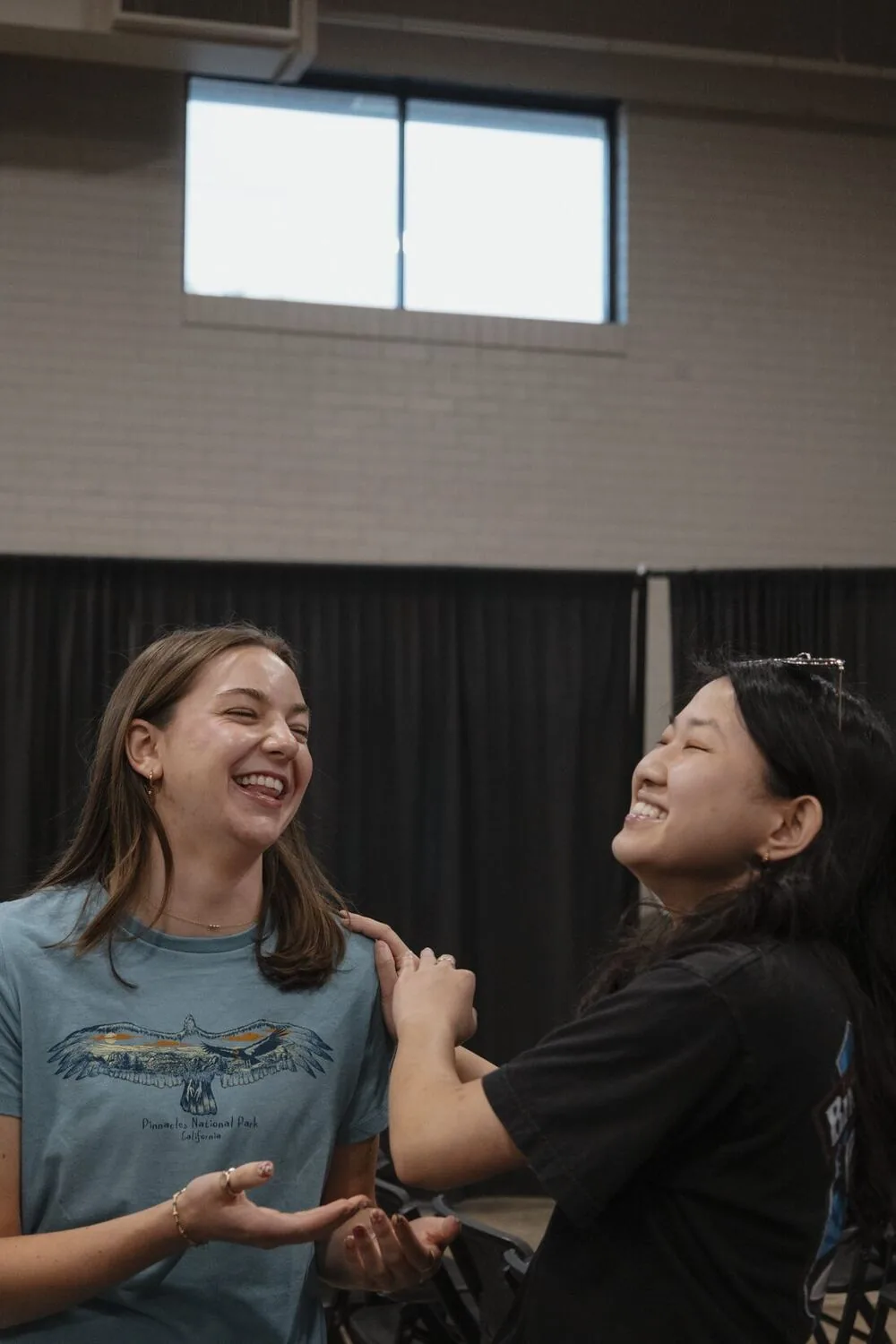 Two young women laughing together.