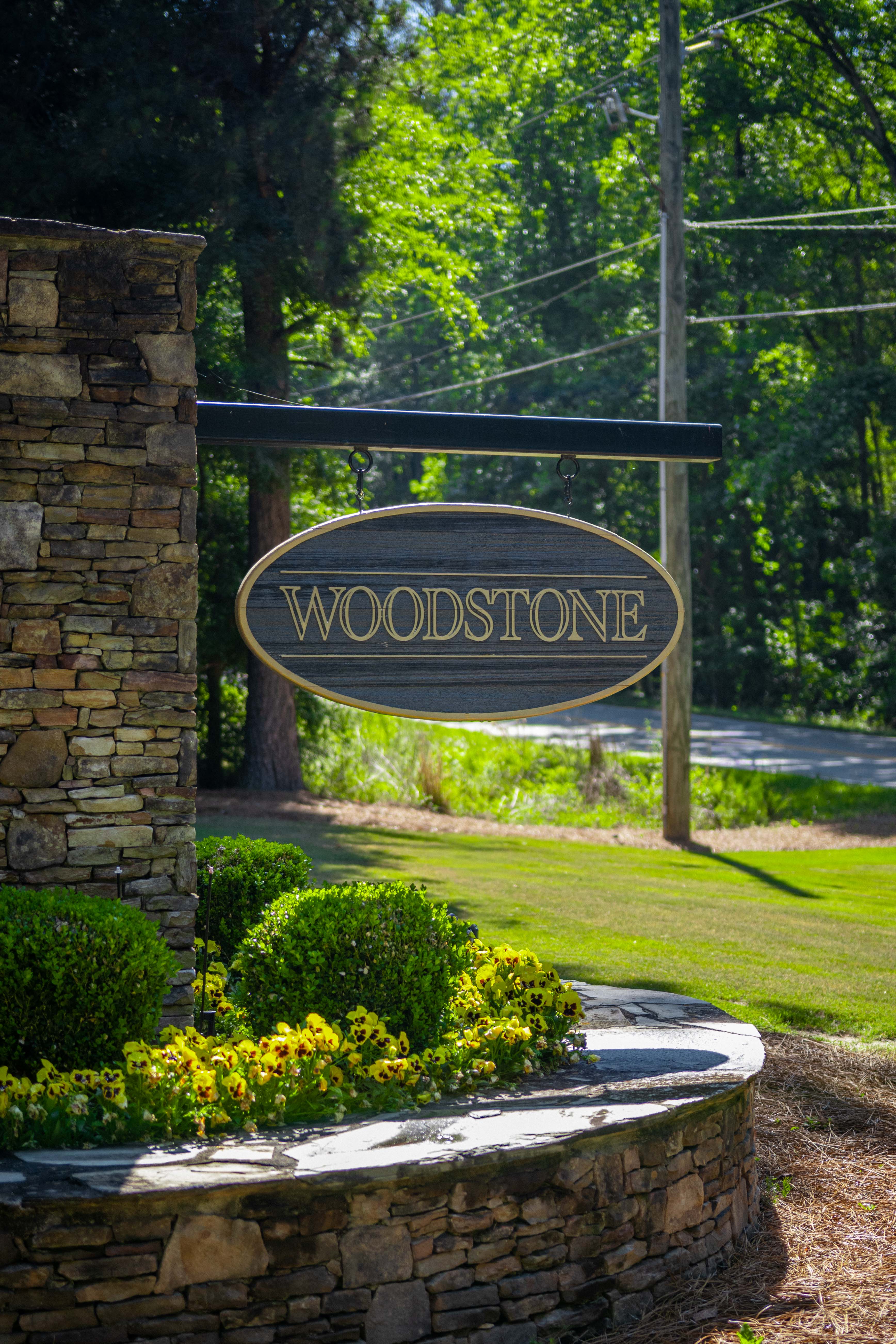 Woodstone neighborhood entrance sign framed by mature landscaping in North Augusta